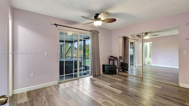 spare room with ceiling fan, a textured ceiling, and wood-type flooring