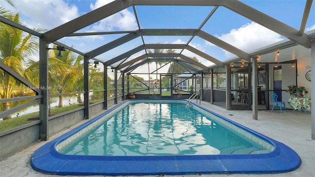 view of pool with a water view, glass enclosure, and a patio area