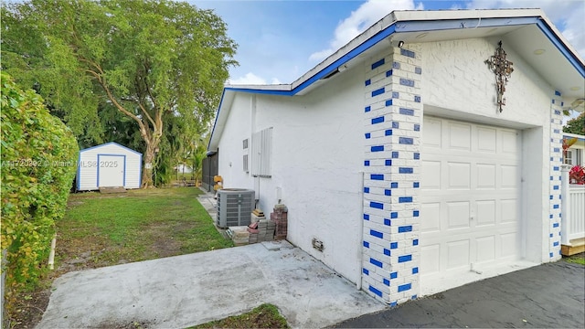 view of home's exterior featuring a garage, a storage unit, and central AC unit