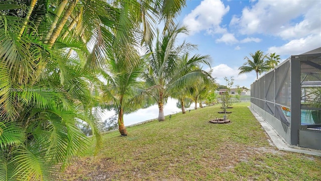 view of yard with a pool, a lanai, and a water view