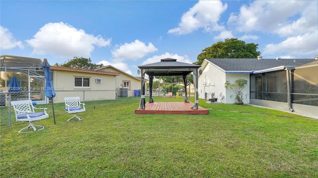 view of yard with a wooden deck, glass enclosure, and a gazebo