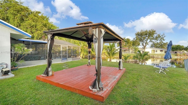 view of yard featuring a lanai and a deck with water view