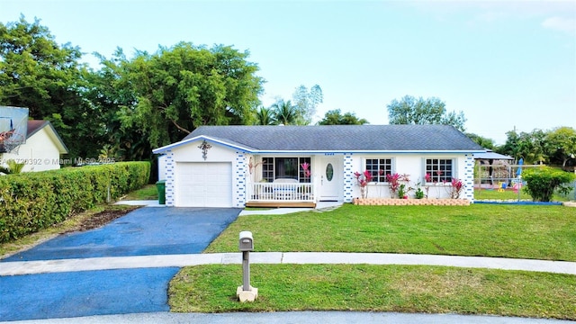 view of front of home featuring a garage, a porch, and a front lawn