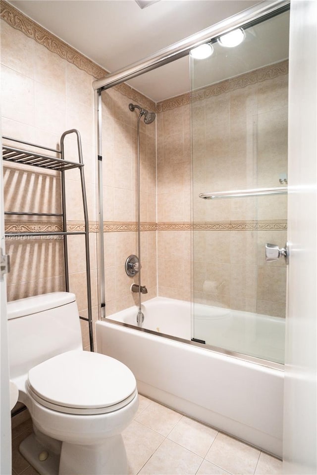 bathroom with toilet, shower / bath combination with glass door, and tile patterned flooring