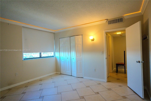 unfurnished bedroom featuring crown molding, a textured ceiling, and a closet