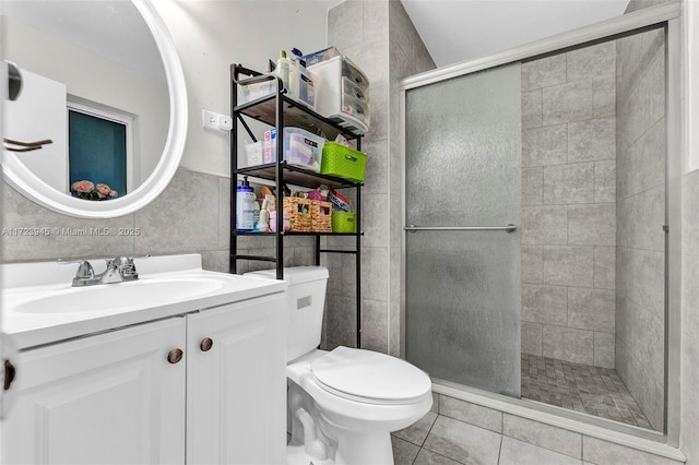 bathroom featuring toilet, tile patterned flooring, tile walls, an enclosed shower, and vanity