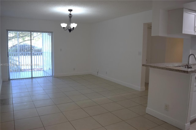 unfurnished dining area with light tile patterned floors and an inviting chandelier