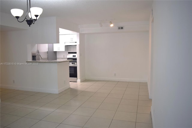 kitchen featuring stainless steel appliances, decorative light fixtures, a notable chandelier, white cabinetry, and light tile patterned flooring