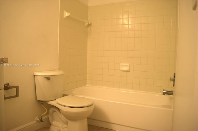 bathroom featuring tile patterned flooring, tiled shower / bath combo, and toilet