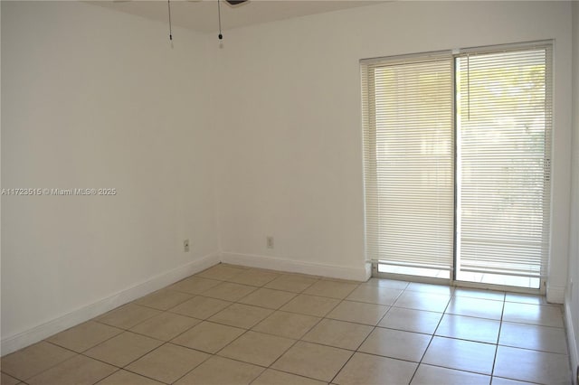 tiled spare room featuring ceiling fan