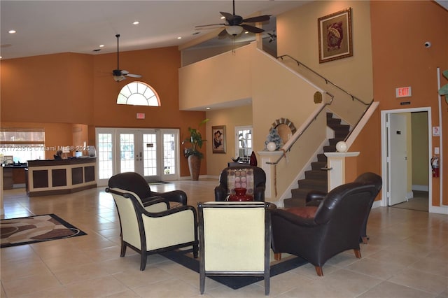 living room with ceiling fan, french doors, light tile patterned floors, and a high ceiling