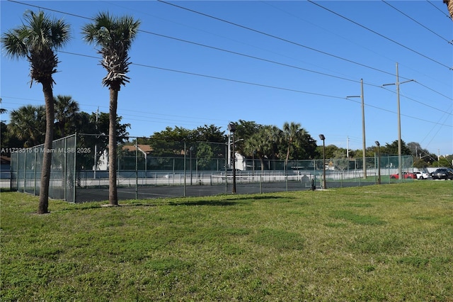 view of sport court with a lawn and basketball court