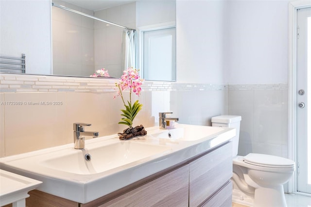 bathroom featuring curtained shower, vanity, tile walls, and toilet