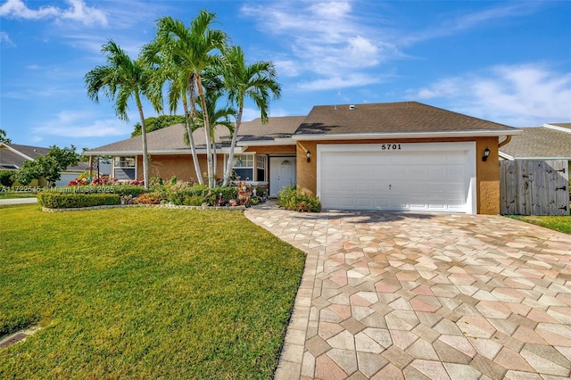 ranch-style house featuring a garage and a front lawn