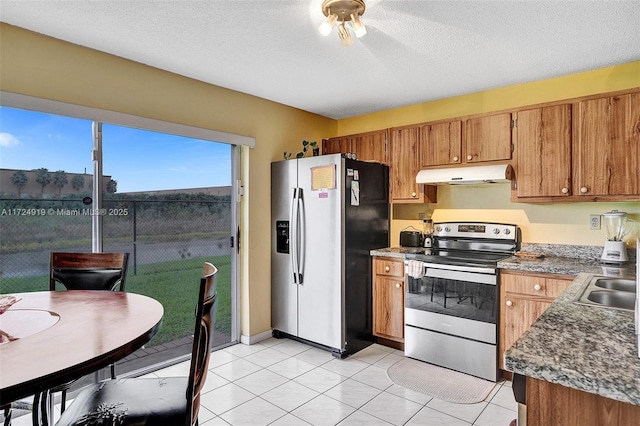 kitchen featuring light tile patterned floors, a textured ceiling, stainless steel appliances, and sink