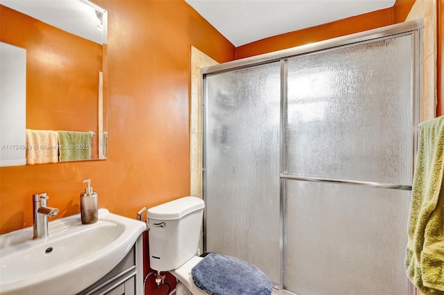 bathroom with vanity, a shower with shower door, and toilet