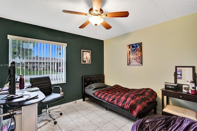 tiled bedroom featuring ceiling fan and a textured ceiling