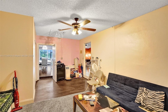 living room with dark colored carpet, a textured ceiling, and ceiling fan