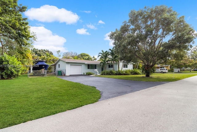 view of front facade with an attached garage, driveway, fence, and a front yard