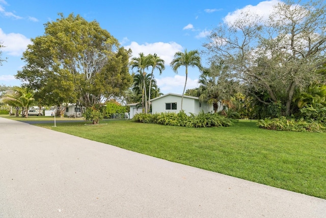 view of front of home with driveway, a front lawn, and an attached garage