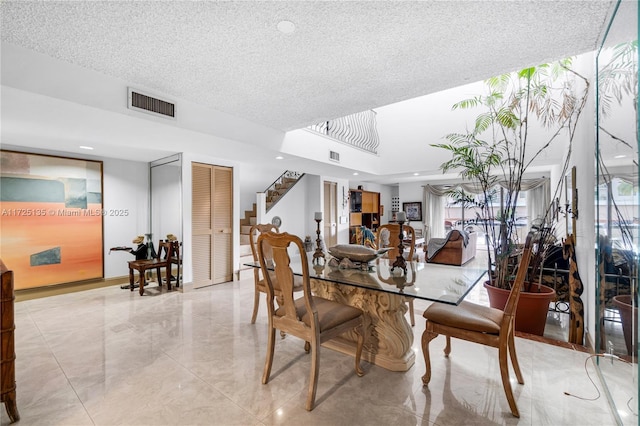 dining room featuring a towering ceiling and a textured ceiling