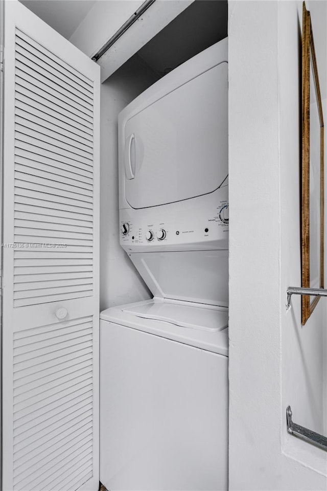 washroom featuring stacked washer / dryer