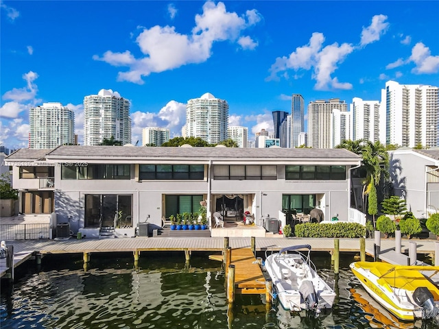 rear view of property with cooling unit and a water view