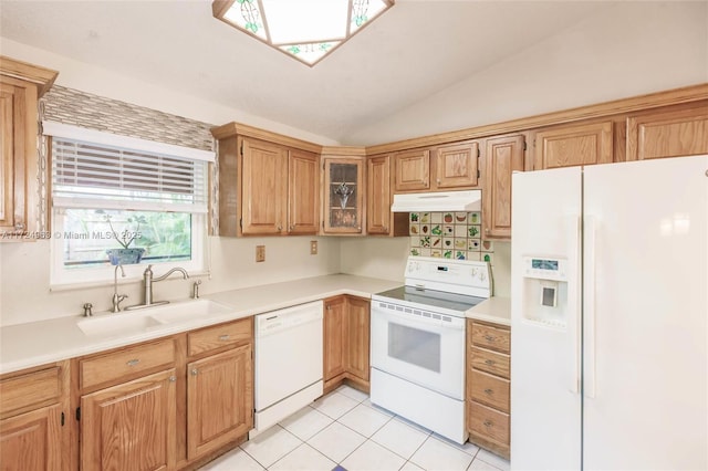 kitchen with under cabinet range hood, light countertops, lofted ceiling, white appliances, and a sink