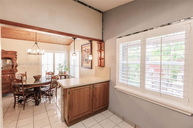 kitchen featuring a chandelier, pendant lighting, light countertops, a peninsula, and light tile patterned flooring