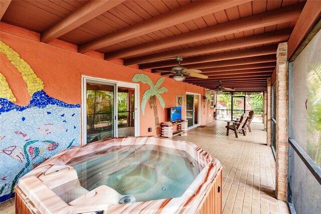 wooden terrace featuring a ceiling fan and a hot tub