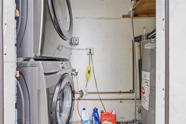 utility room featuring stacked washer / drying machine and water heater