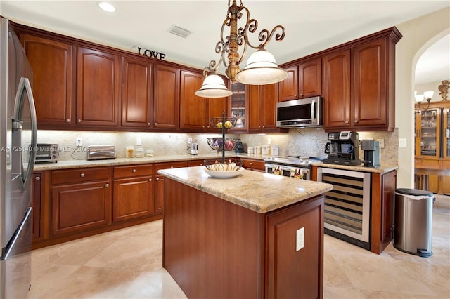 kitchen with a kitchen island, decorative light fixtures, tasteful backsplash, wine cooler, and stainless steel appliances