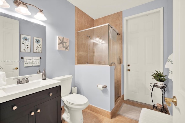 bathroom with tile patterned flooring, vanity, a shower with door, and toilet