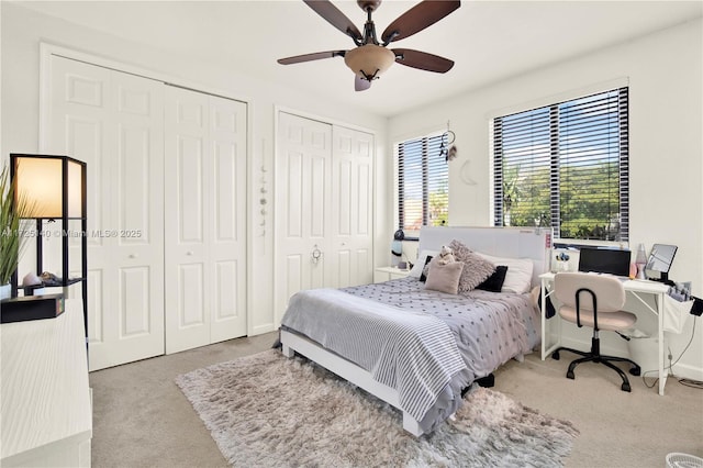 carpeted bedroom featuring two closets and ceiling fan