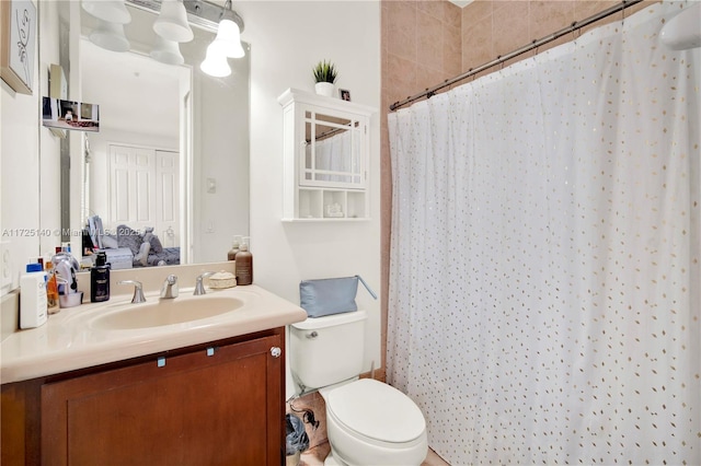 bathroom with walk in shower, vanity, and toilet