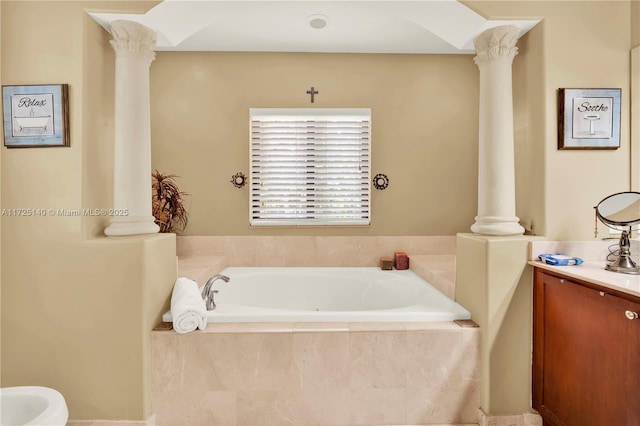 bathroom with a bidet, vanity, tiled tub, and ornate columns