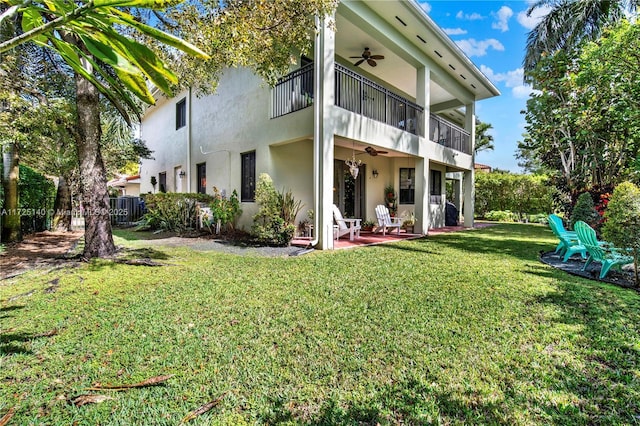 back of property with a patio, a sunroom, ceiling fan, and a lawn