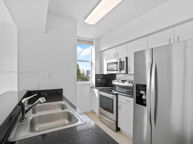 kitchen featuring white cabinets, decorative backsplash, sink, and stainless steel appliances