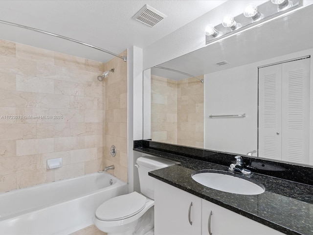 full bathroom featuring toilet, tiled shower / bath, and vanity