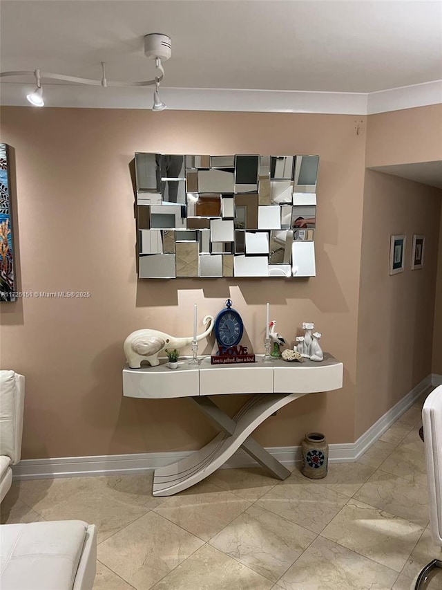 interior space with track lighting and crown molding