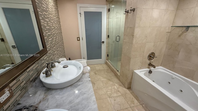 bathroom with a tub with jets, tiled shower, and vanity