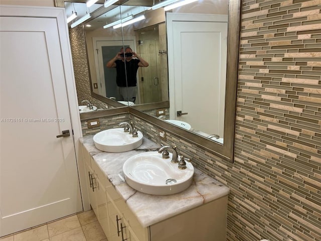 full bathroom with double vanity, a shower stall, a sink, and tile patterned floors