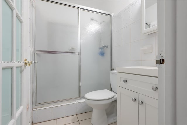 bathroom featuring vanity, an enclosed shower, tile patterned flooring, and toilet