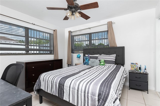 tiled bedroom featuring multiple windows and ceiling fan