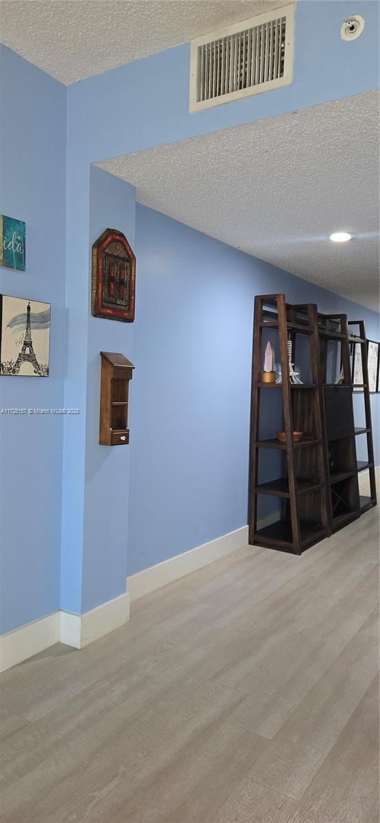 spare room featuring a textured ceiling and hardwood / wood-style floors