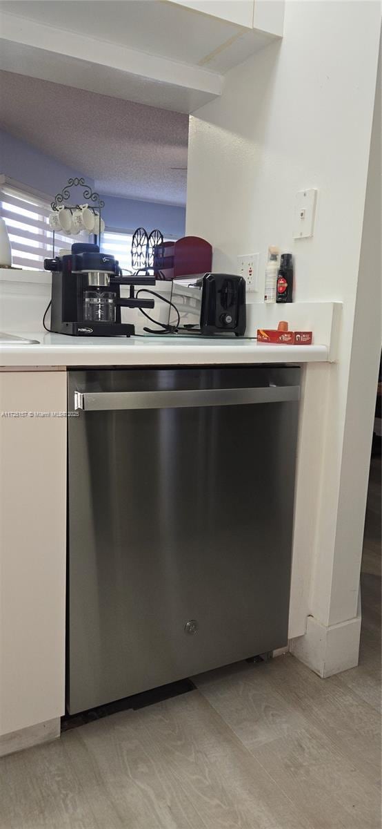 kitchen featuring stainless steel dishwasher and white cabinetry