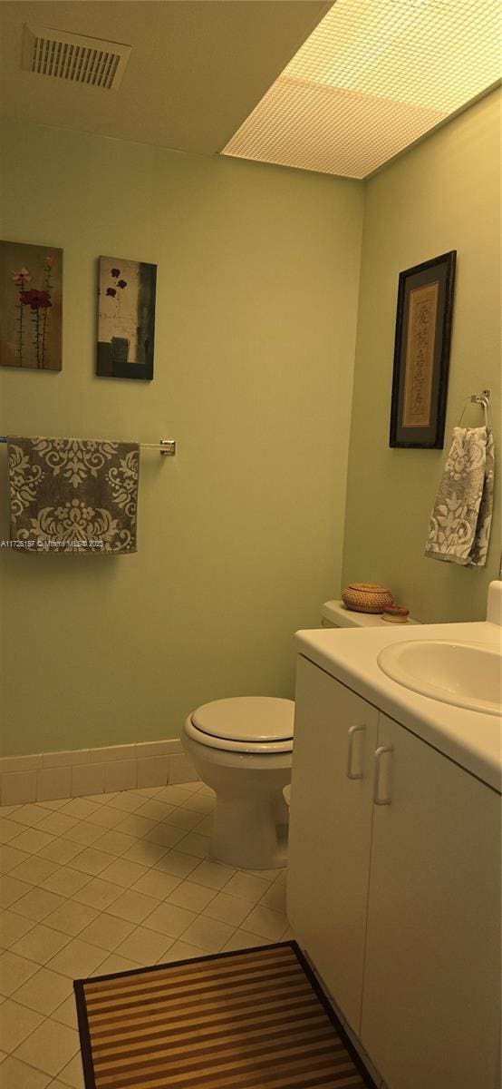 bathroom with tile patterned flooring, vanity, and toilet