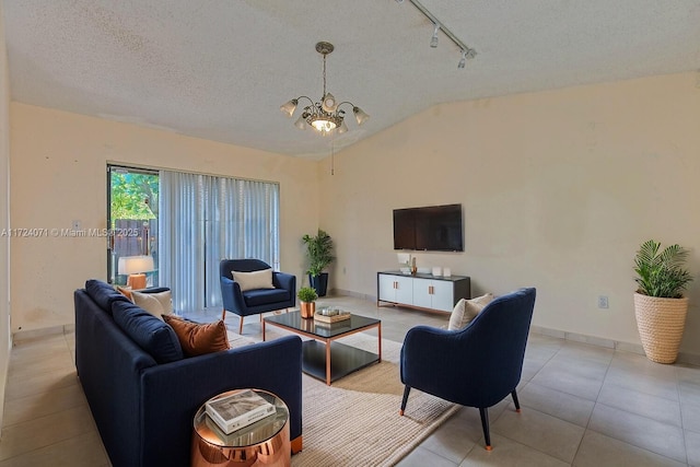 tiled living room featuring a textured ceiling, a notable chandelier, lofted ceiling, and rail lighting