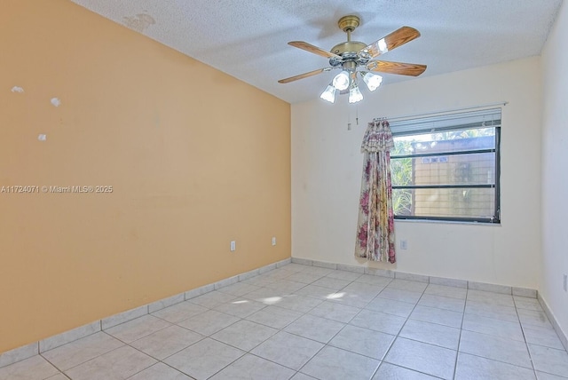 tiled spare room featuring ceiling fan and a textured ceiling