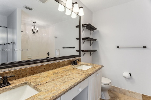 bathroom with an inviting chandelier, a shower, vanity, and toilet